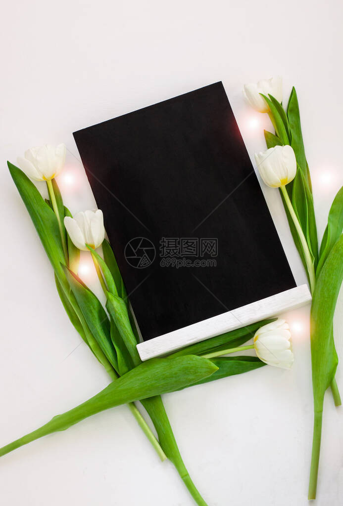 黑色粉笔板样机与白色背景上的郁金香花图片