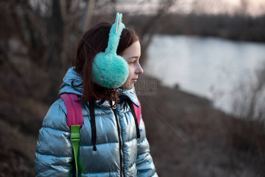 美丽的年轻女子的画像冬季在河流附近拍摄Plein空气照片一个少年的肖像女孩9岁女学生背着包在河边散步图片