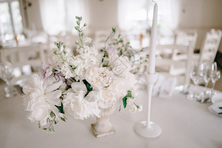 婚宴餐桌布置白色圆桌上的盘子眼镜餐具和鲜花圆桌与白色桌布用图片