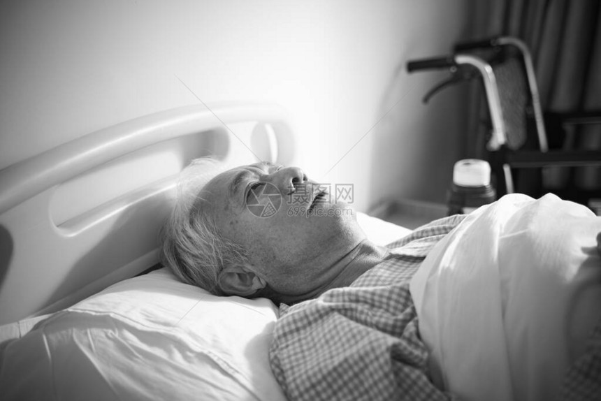 睡在医院床上的老年病老人似乎感到悲哀无图片