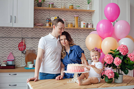 餐桌上的一家人拿着生日蛋糕和气球背景图片