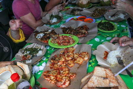鱼烧烤在火上烹饪烧烤海鲜用燃烧的煤烧烤在金巴兰热带巴厘岛的鱼市场上图片