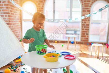 可爱的金发小子在幼儿园玩塑料食品围着很多玩背景图片