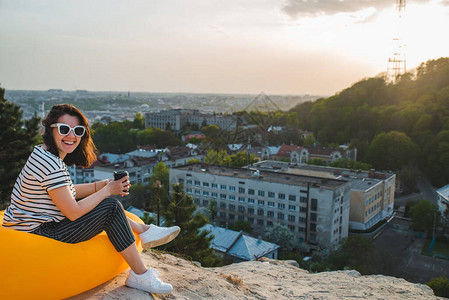 妇女喝咖啡在乌拉茵的利维夫市上空看到美图片