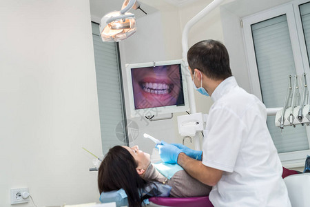 使用照相机检查病人牙齿的牙科图片