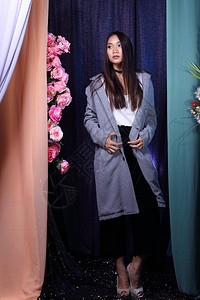 亚洲女长直发白衬衫黑色裤子灰色外套站在粉色玫瑰花上的时尚姿势图片