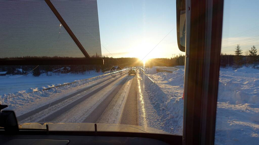 巴士日落时在瑞典北部的雪地路上看到公共图片