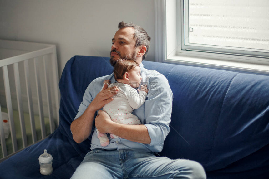 中年白人父亲与熟睡的新生女婴父母手里拿着摇摆的孩子女儿子正宗的生活方式为人父母的时刻单亲图片