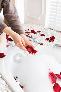 在浴袍中种植妇女在家中用玫瑰图片