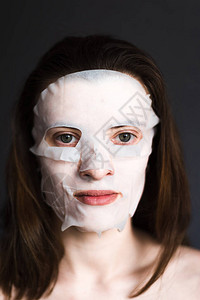 带组织保湿化妆面膜的年轻女图片