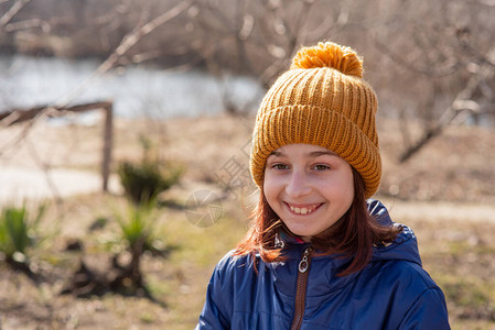 暖冬来袭九岁的女孩在户外享受冬天9岁的女孩戴着帽子和夹克女孩岁的肖像宝很开心真诚的微笑少年春天来了暖冬背景