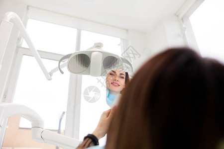 满意的牙科病人妇女照镜子看牙科治疗的结果b图片