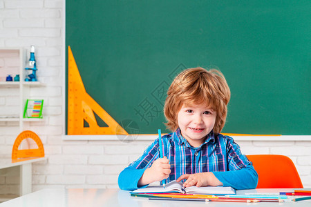 小学生在室内学习的肖像学生习字母和数字可爱的学龄前小男孩和老师图片