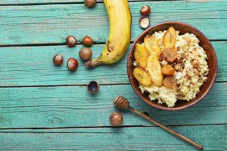 小米粥配焦糖香蕉和坚果健康早餐图片