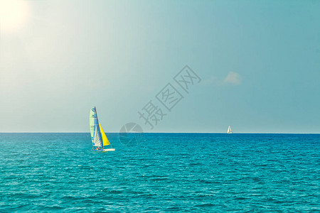 夏日在开阔平坦的大海中航行的小型个人帆船图片