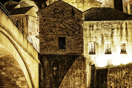 波斯尼亚和黑塞哥维那莫斯塔尔的古董石屋在夜幕时照亮图片