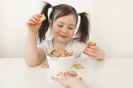 孩子们吃面筋饼干一个亚洲长相的婴儿吃着美味的糕点婴图片