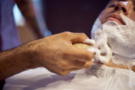 理发店的胡须剃过程师父让客户用老式直剃刀刮胡子在理发店工作图片