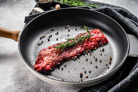 Raw大理石牛肉排锅里有烹饪素材的肉片灰色背图片