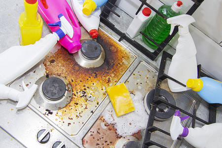 肮脏的厨房炉灶周围空荡的和满瓶的洗涤剂图片