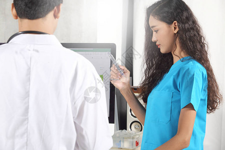 医生护士和穿制服的病人用听诊器讨论和检查日常清单上的健康状况图片