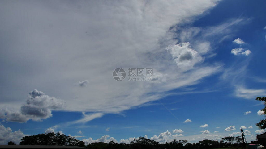 以蓝天空和独特白云为背景的田地树木自然景色图片