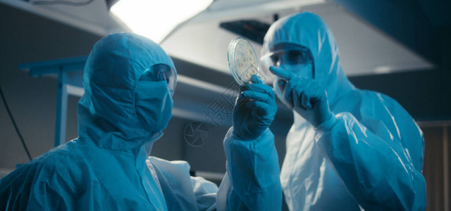 研究人员穿着防护装备并在实验室检查冠状病图片