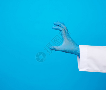 手戴蓝色无菌橡胶手套上面有物体蓝底图片