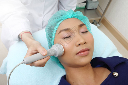 医院诊所面部高频医疗美容仪治疗亚洲女患者使皮肤光滑亮图片