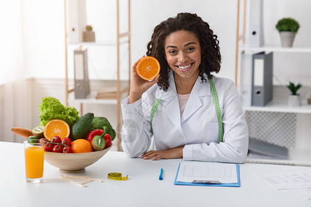 现代饮食学家非洲女坐在工作场所图片