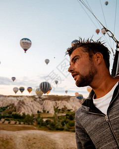 度假的年轻人卡帕多西亚土耳其日出在山上与热气球图片