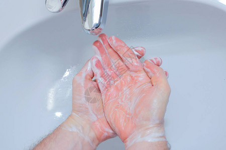 一个男人在浴室里用肥皂洗手男人的手关闭手部消毒和治疗头孢隔离规图片