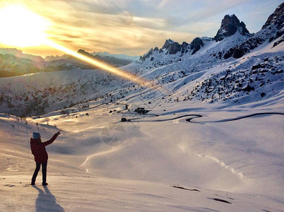 在雪山的女孩赵在日落的冬天穿过意大图片