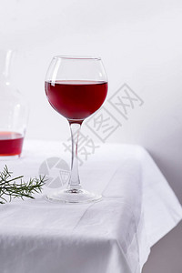 红酒在葡萄酒杯中白色纺织品背景图片