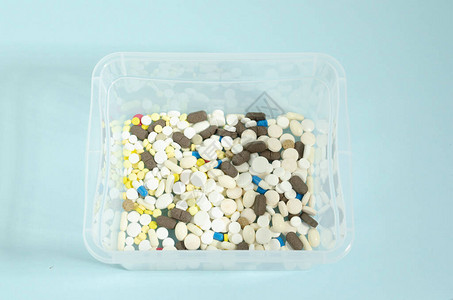 装有药丸的容器多色白药丸放在透明盒子里蓝图片