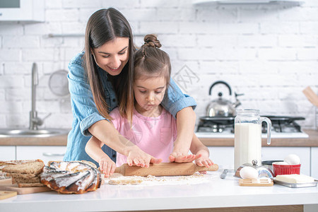 快乐的家庭妈和女儿在厨房准备糕点一个充满爱的家庭和家庭价值观的概念健图片