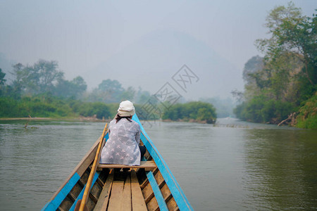小木船在绿色丛林中的野生热带河流中航行背景图片