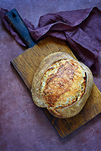 灰蓝色背景上由小麦和全麦面粉制成的自制新鲜出炉的乡村面包图片