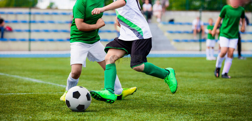 运行足球员青年足球队之间的体育比赛硬决斗中踢足球比赛的年轻男孩少年足球图片