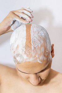 男人用白色泡沫剃光头图片
