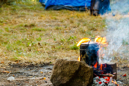 露营时在营火上做饭背着景图片