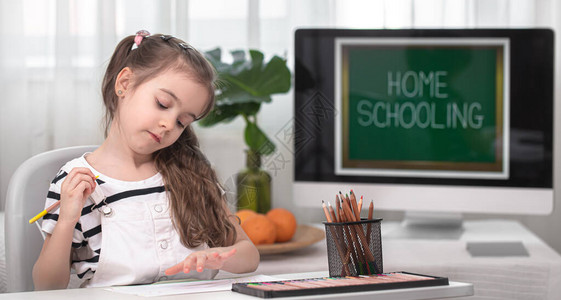 这个女孩正坐在桌旁做作业孩子在家在家上学图片