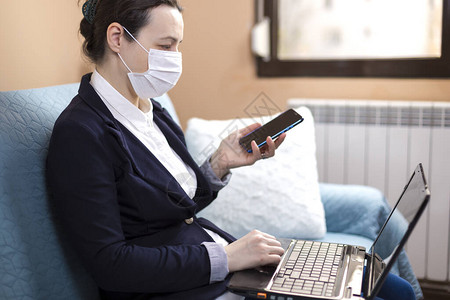 在家工作的戴医用口罩的妇女检疫期间在图片