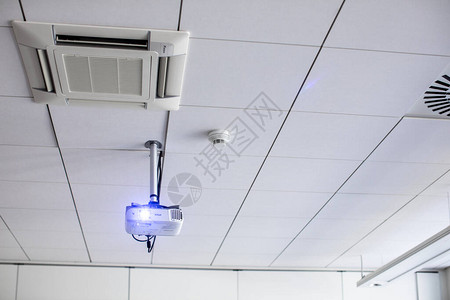 会议室现代教室天花板上的白色高空投影机背景图片