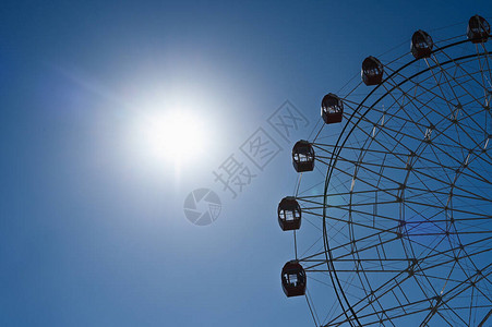 天空和太阳背景上的摩天轮天空背景上的摩天轮在晴朗的天空图片