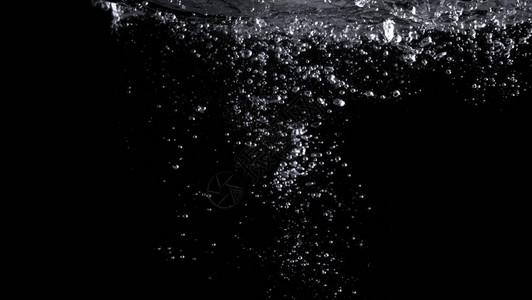 真实苏打气泡在黑色背景中漂浮和溅起的模糊图像背景图片