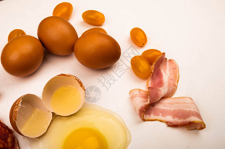 白色背景上的碎鸡蛋鸡蛋培根片和西红柿特写图片