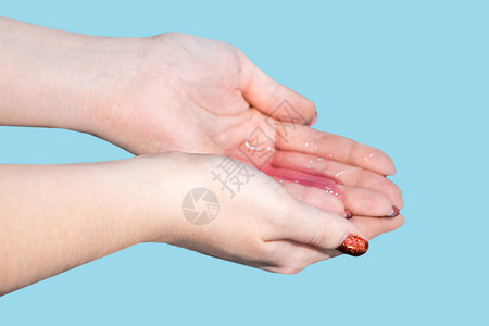 一名妇女用蓝色背景的肥皂洗手和消毒双手冠状防护洗手说明个图片