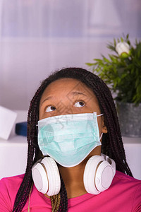 紧闭一个戴着外科面具朝上看的脖子上戴了脚镣和耳机的少女疾病和预防概图片