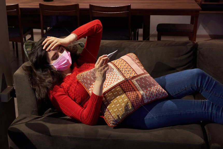 沙发上覆盖着毯子冻吹流鼻涕的年轻女子发烧被抓生病的女孩出现流感症状流图片